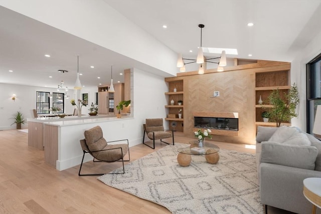 216 Aspinwall Ave, Brookline, MA 02446 - living room featuring recessed lighting, baseboards, light wood-type flooring, vaulted ceiling, and a premium fireplace