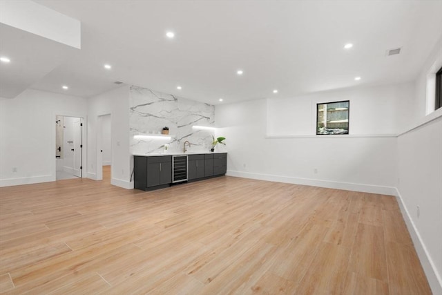 216 Aspinwall Ave, Brookline, MA 02446 - unfurnished living room featuring beverage cooler, recessed lighting, light wood-type flooring, baseboards, and a sink