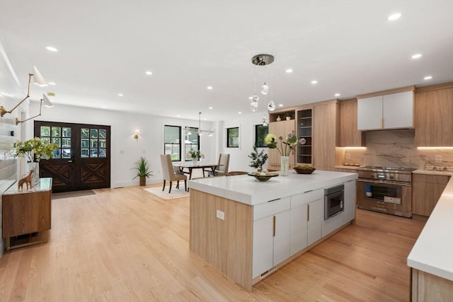 216 Aspinwall Ave, Brookline, MA 02446 - kitchen featuring stainless steel stove, modern cabinets, recessed lighting, a center island, and light countertops