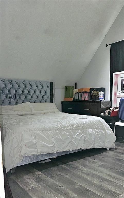 bedroom featuring hardwood / wood-style flooring and vaulted ceiling