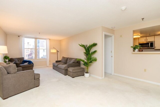 living area with baseboards and carpet