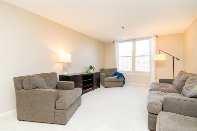 carpeted living room featuring baseboards