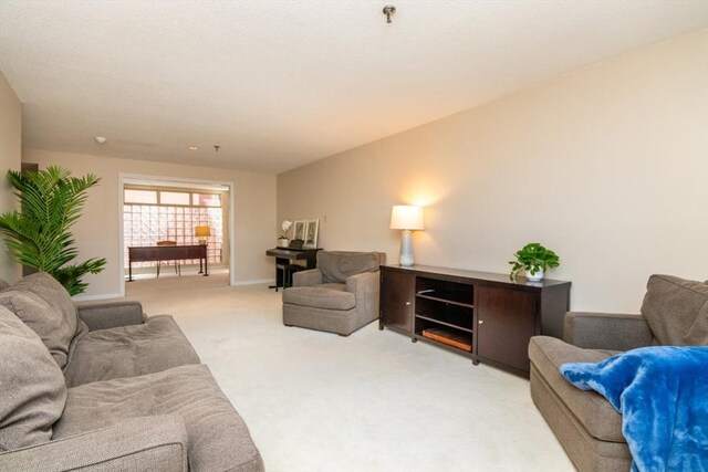 living area featuring light colored carpet and baseboards