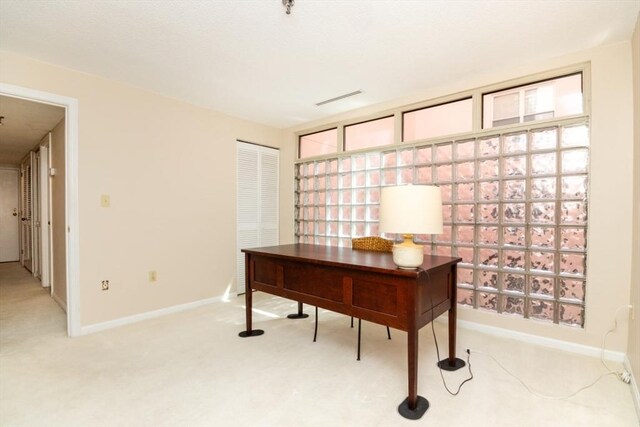 home office with light colored carpet and baseboards