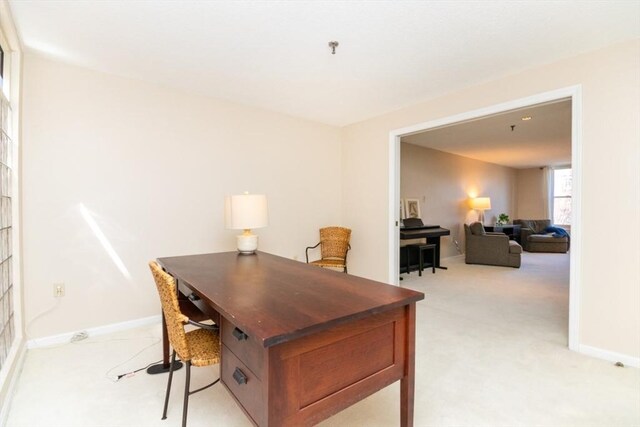 office area featuring baseboards and light colored carpet