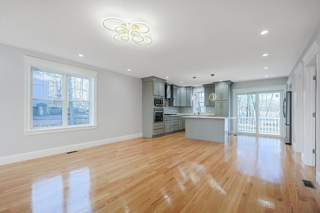 unfurnished living room with light wood-type flooring and sink