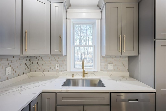 kitchen with gray cabinetry, stainless steel dishwasher, sink, and a wealth of natural light