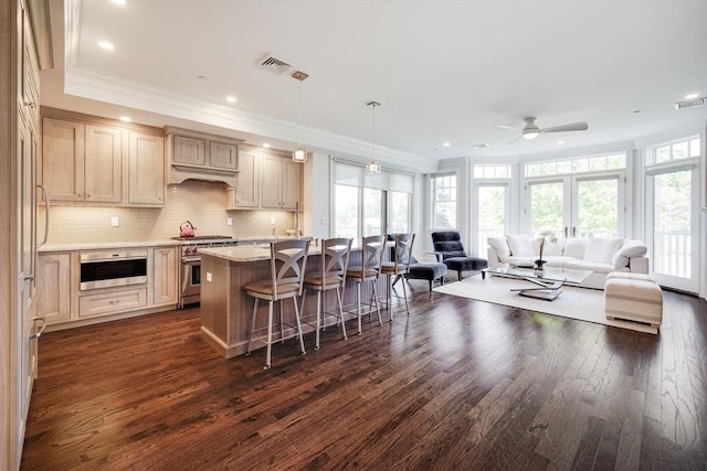 66 Simons Unit C, Mashpee, MA 02649 - kitchen featuring high end stainless steel range oven, open floor plan, a breakfast bar area, dark wood-style floors, and ornamental molding
