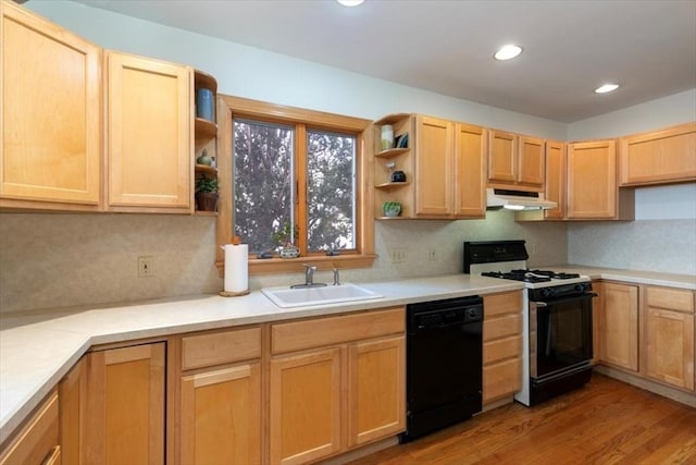 kitchen with light brown cabinetry, sink, black appliances, and light hardwood / wood-style floors