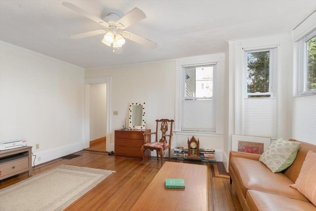 sitting room with ceiling fan, light wood-type flooring, and crown molding