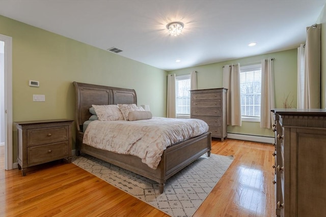 bedroom featuring light wood finished floors, recessed lighting, visible vents, and baseboard heating