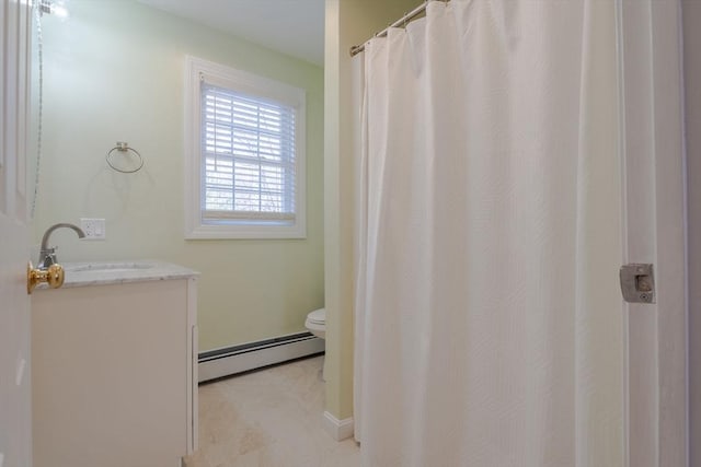 bathroom with toilet, vanity, and a baseboard radiator