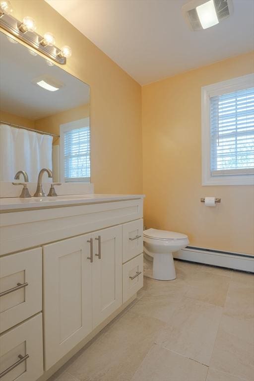 bathroom featuring a baseboard radiator, plenty of natural light, toilet, and vanity