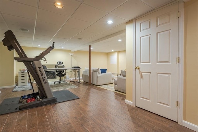 workout room with recessed lighting, baseboards, and wood finished floors