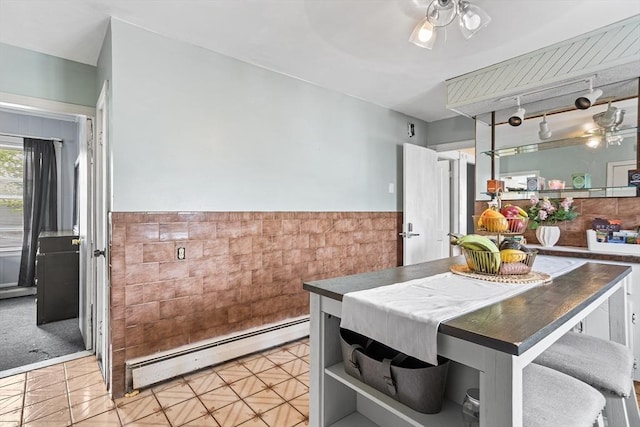 369-371 Mill St, New Bedford, MA 02740 - dining space with a baseboard heating unit, tile walls, wainscoting, a ceiling fan, and light tile patterned floors