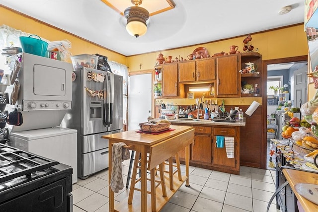 369-371 Mill St, New Bedford, MA 02740 - kitchen featuring stainless steel refrigerator with ice dispenser, stacked washer / dryer, brown cabinetry, light tile patterned flooring, and open shelves