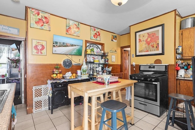 369-371 Mill St, New Bedford, MA 02740 - kitchen featuring stainless steel range with gas cooktop, light tile patterned floors, and a wainscoted wall