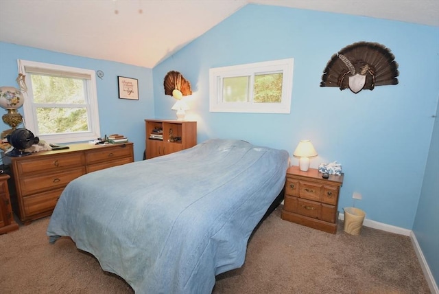 bedroom featuring light carpet, lofted ceiling, and baseboards