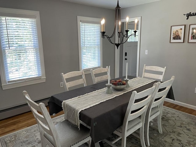 dining space with a healthy amount of sunlight, an inviting chandelier, baseboards, and wood finished floors