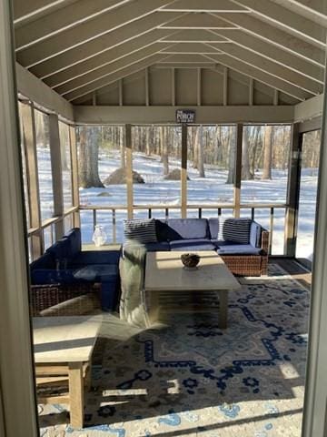 sunroom featuring vaulted ceiling and a healthy amount of sunlight