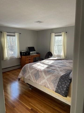 bedroom featuring a baseboard radiator and wood finished floors