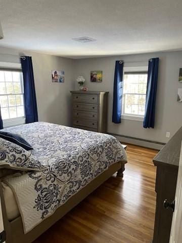 bedroom featuring a baseboard radiator and wood finished floors