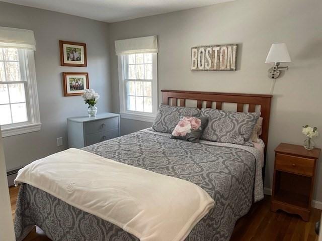 bedroom featuring a baseboard heating unit and wood finished floors