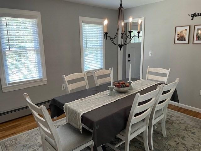 dining room with baseboards, an inviting chandelier, and wood finished floors