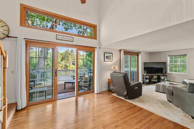 72 S Shore Dr, Sturbridge, MA 01566 - living area with wood finished floors, baseboards, a towering ceiling, and a ceiling fan