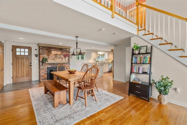 72 S Shore Dr, Sturbridge, MA 01566 - dining room with light wood-style floors, a brick fireplace, stairs, recessed lighting, and baseboards