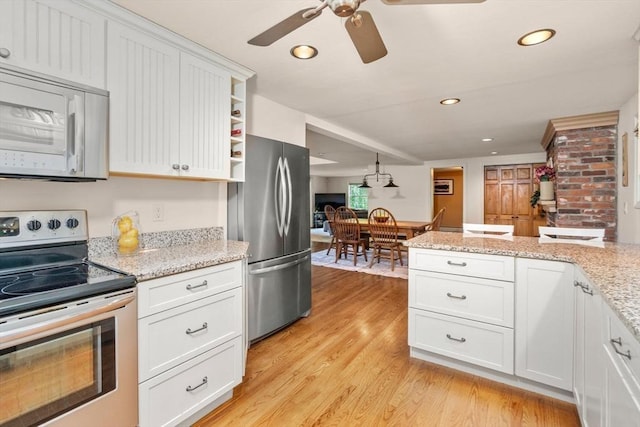 72 S Shore Dr, Sturbridge, MA 01566 - kitchen with stainless steel appliances, a ceiling fan, light wood-type flooring, white cabinetry, and light stone countertops