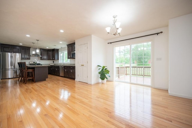 7 Willow Brook Ln, Blackstone, MA 01504 - kitchen with appliances with stainless steel finishes, a chandelier, wall chimney range hood, light wood-style floors, and pendant lighting