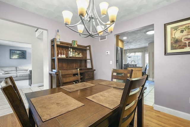 dining space featuring an inviting chandelier and light hardwood / wood-style flooring