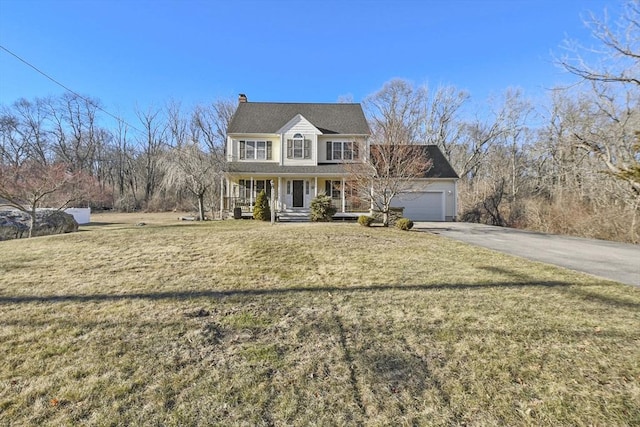 view of front of home featuring a garage, a front yard, and covered porch