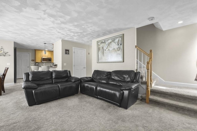 living room featuring light colored carpet and a textured ceiling