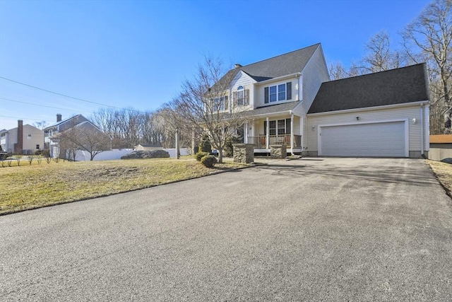 view of front of property with a garage, a front yard, and a porch