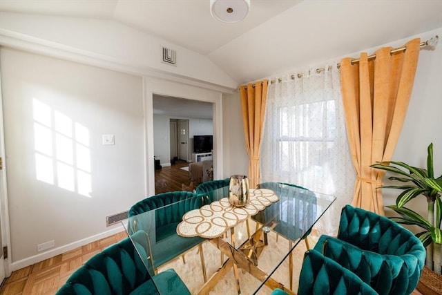 dining room featuring lofted ceiling and baseboards
