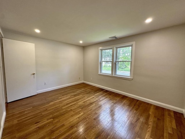 unfurnished room featuring wood-type flooring, baseboards, and recessed lighting