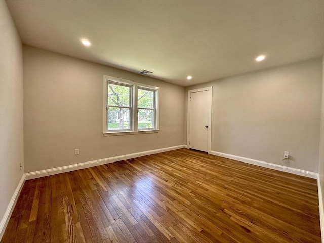 unfurnished room featuring hardwood / wood-style flooring, baseboards, and recessed lighting