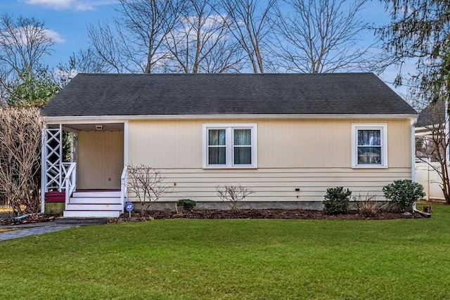view of front of home with a front lawn and a shingled roof