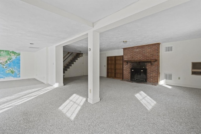 unfurnished living room featuring light carpet, stairway, a fireplace, and visible vents