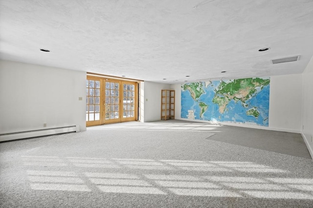 carpeted spare room featuring visible vents, baseboards, a textured ceiling, french doors, and a baseboard heating unit