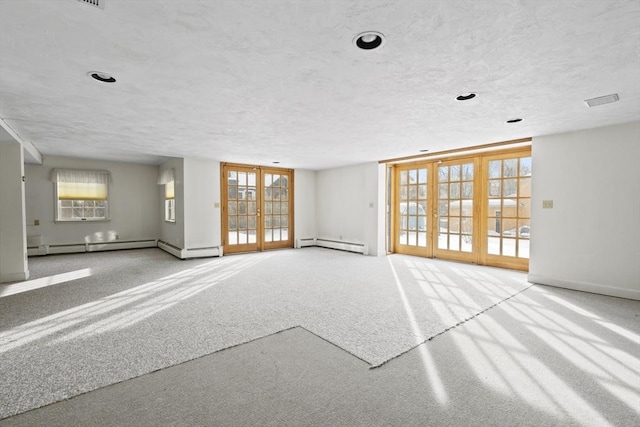 unfurnished living room featuring visible vents, light colored carpet, a baseboard radiator, a textured ceiling, and french doors