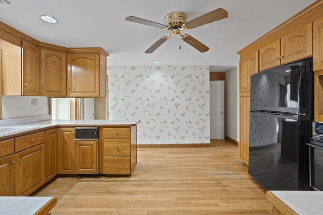 kitchen featuring black appliances, light countertops, light wood-style flooring, and wallpapered walls