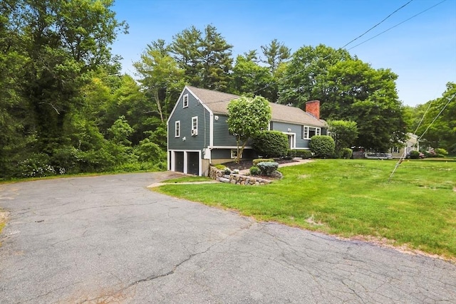 5 Fox Run Rd, Topsfield, MA 01983 - view of home's exterior with a chimney, a garage, asphalt driveway, and a yard