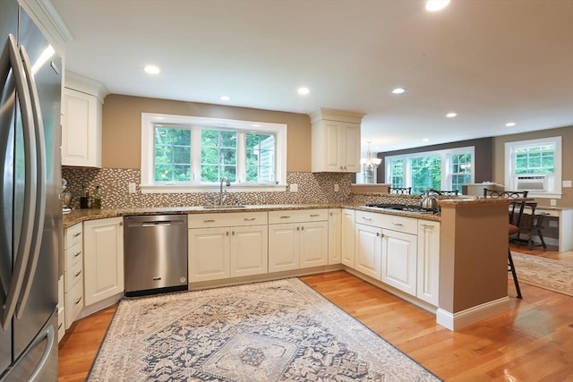 5 Fox Run Rd, Topsfield, MA 01983 - kitchen with appliances with stainless steel finishes, light wood finished floors, stone countertops, tasteful backsplash, and a peninsula