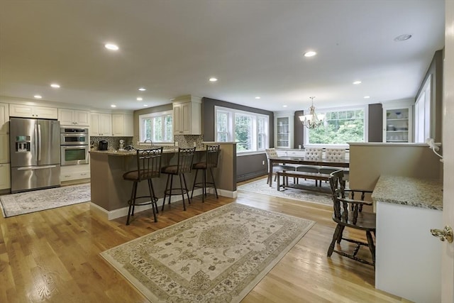 5 Fox Run Rd, Topsfield, MA 01983 - kitchen with stainless steel appliances, a chandelier, a breakfast bar, tasteful backsplash, and recessed lighting