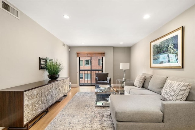 living room featuring recessed lighting, visible vents, light wood-style flooring, and baseboards