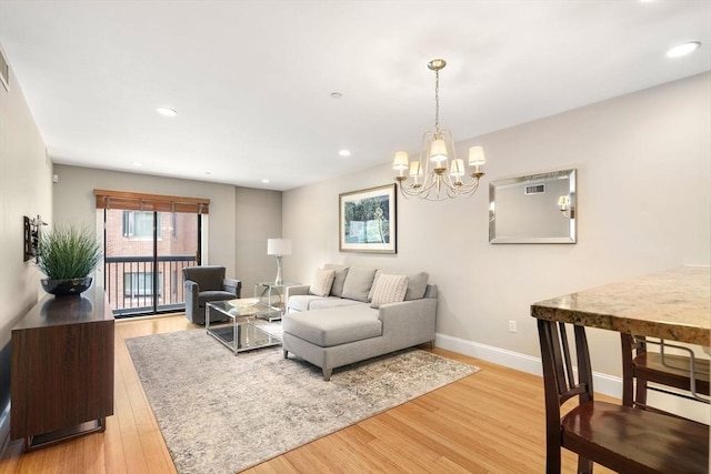 living room with recessed lighting, a notable chandelier, baseboards, and light wood-style floors