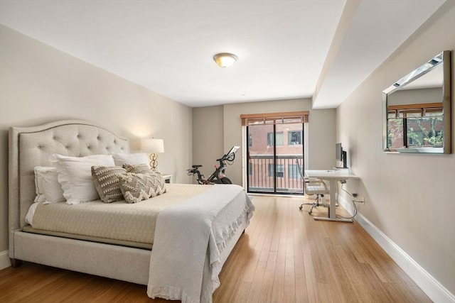 bedroom with light wood-style flooring, baseboards, and access to outside